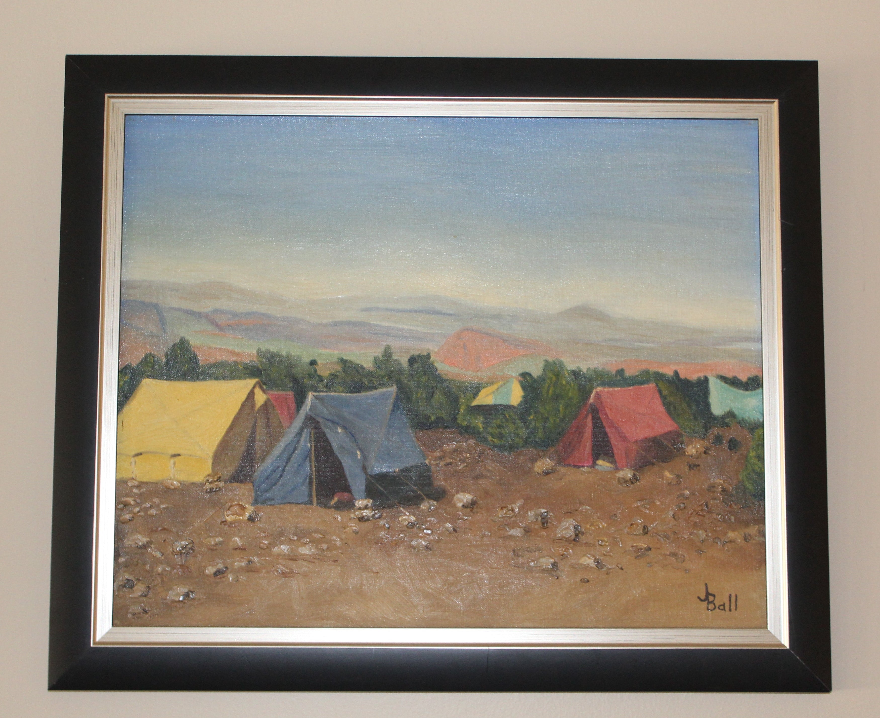 Framed painting of tents in a desert landscape 